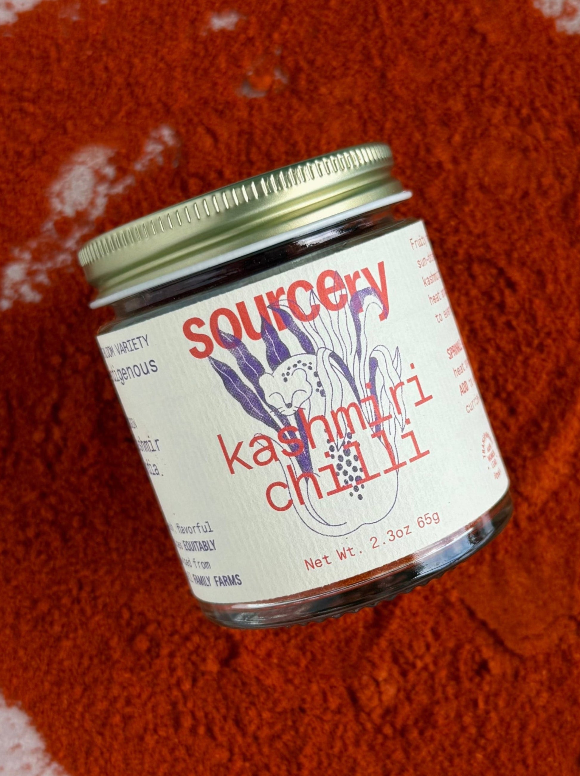 Jar of Sourcery Kashmiri Chilli on a red textured surface